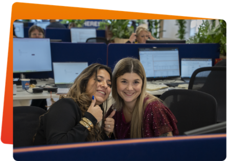 Medewerker met een salesUp-hoodie waarop 'A job in sales?' staat, met headset op de werkvloer.