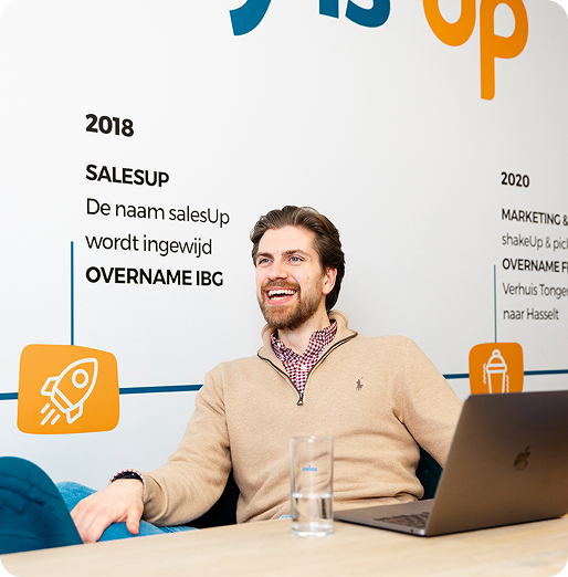 Medewerkers van salesUp in overleg rond een sta-tafel op de hoofdzetel in Erpe-Mere.
