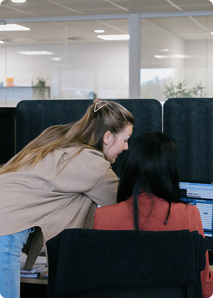 Een salesconsultant in overleg met een collega aan een bureau.